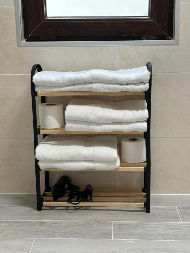 a stack of towels and towels on a shelf in a bathroom at Cozy Cottages Kondidi in Kobuleti