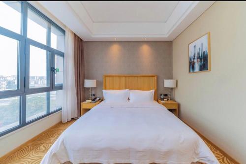 a bedroom with a large bed and two windows at Holiday Inn Foshan Nanhai Central by IHG in Foshan