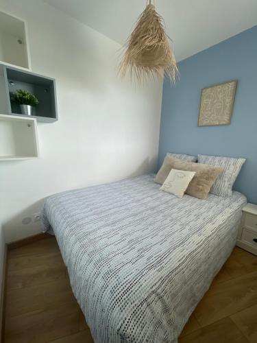 - une chambre dotée d'un lit avec un mur bleu dans l'établissement Bel appartement vue mer accès direct plage, à Canet