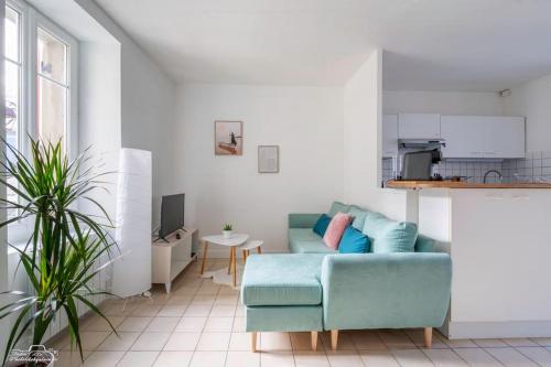 un salon avec un canapé bleu et une cuisine dans l'établissement Escale à Nantes - Bord de Loire, à Rezé