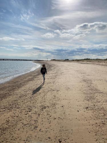 a person walking on a beach near the water at VerbJam 6 Berth Caravan Holiday St Osyth Clacton-on-sea in Clacton-on-Sea