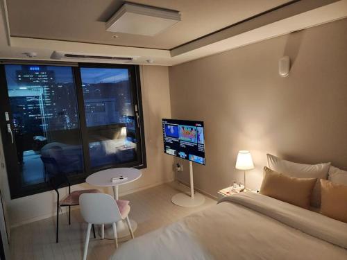 Schlafzimmer mit einem Bett, einem Tisch und einem TV in der Unterkunft 동성로 Residence Daon in Daegu
