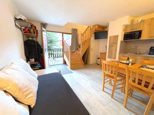 une chambre avec un lit et une cuisine avec une table dans l'établissement Chez Caroline, duplex familial, à Saint-Étienne-en-Dévoluy
