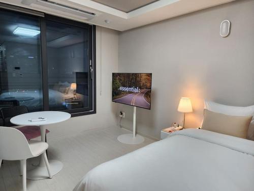 1 dormitorio con 1 cama, TV y mesa en 동성로 Residence Daon en Daegu