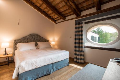 a bedroom with a bed and a large window at Hotel Ristorante Magia del Brenta in Fiesso dʼArtico