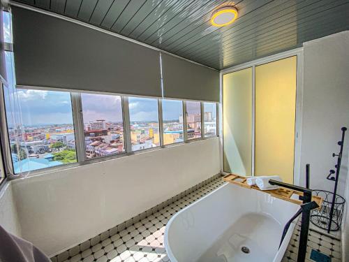 uma casa de banho com uma banheira grande e uma janela em Muar Traders Hotel em Muar