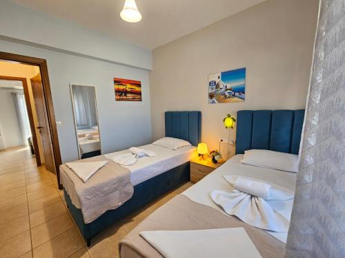 una camera d'albergo con due letti e uno specchio di Holiday House Kallithea a Kallithea