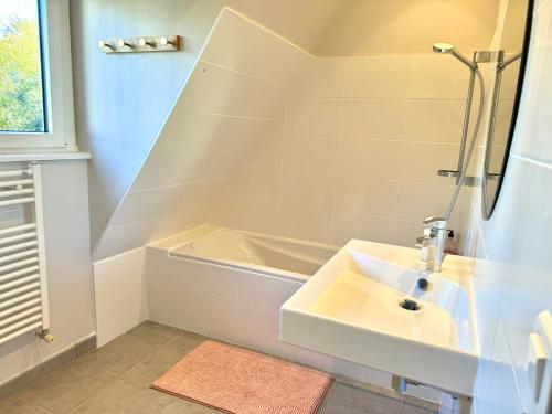 a bathroom with a sink and a bath tub at Bénodet, superbe maison 5 chambres à 150 m de la plage et restaurants in Bénodet