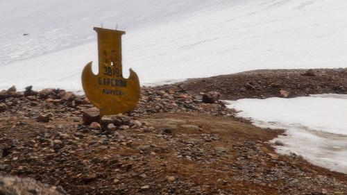 a yellow sign on the side of a snow covered slope at Guest House Shirin in Barskoon
