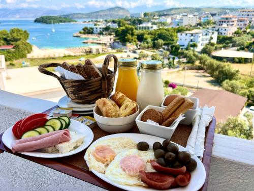 bandeja de desayuno con productos de desayuno en la mesa en ILLYRIAN hotel en Ksamil