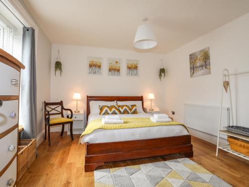 a bedroom with a bed with a yellow blanket at Brigwyn in Pwllheli