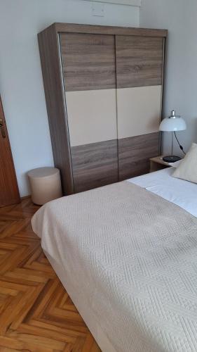 1 dormitorio con 1 cama grande y cabecero de madera en Apartment Manda, en Zadar