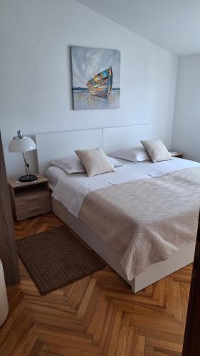 Dormitorio blanco con cama y lámpara en Apartment Manda, en Zadar