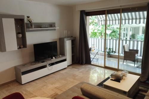 un salon avec une télévision à écran plat et un canapé dans l'établissement Air-conditioned Apartment of 90 m2 only 200 meters away from the Croisette, à Cannes