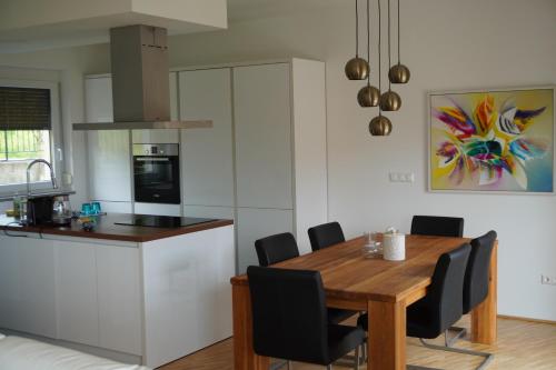 a kitchen and dining room with a wooden table and chairs at Casa Capodistria with sea view in Koper