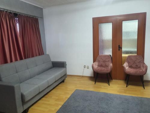 a living room with a couch and two chairs at Apartament 2 camere cazare in Zalău