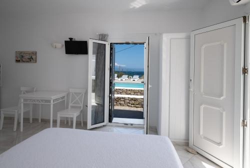 1 dormitorio con cama y vistas al océano en Anixi - Primavera Mykonos en Ornos