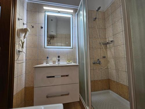 bagno con lavandino e doccia con specchio di Holiday House Kallithea a Kallithea