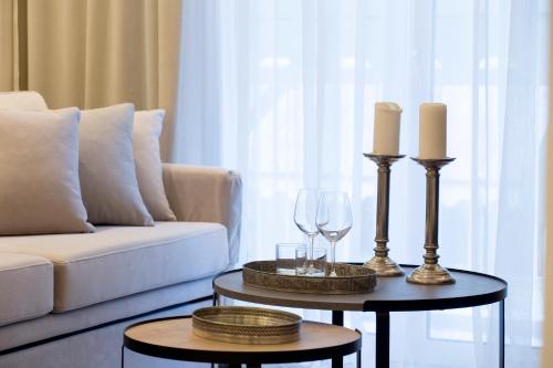 a living room with two tables with candles and wine glasses at La Residence Athens in Athens