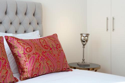 a bed with a red pillow and a lamp on a table at La Residence Athens in Athens