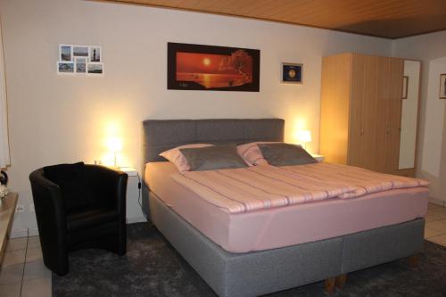 een slaapkamer met een bed en een stoel erin bij Nettes Appartement in Mönchengladbach