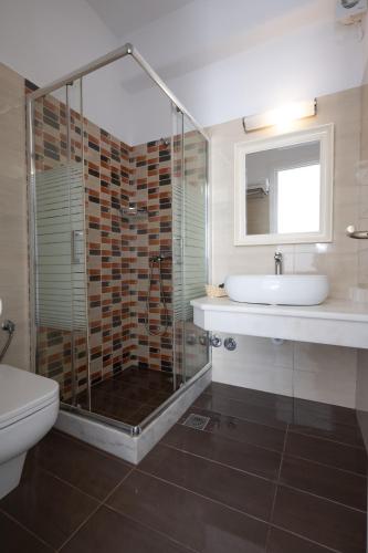 a bathroom with a shower and a sink and a toilet at Anixi - Primavera Mykonos in Ornos