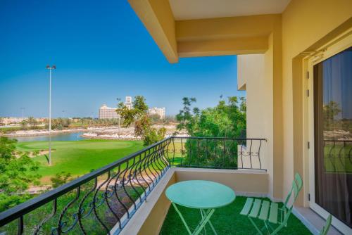 a balcony with a table and chairs and a view at Live surrounded by gorgeous Green Golf fields in Ras al Khaimah