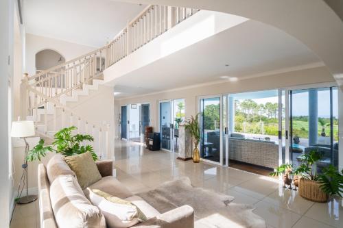 a living room with a couch and a staircase at Pezula 's Paradise in the Sun - No Loadshedding in Knysna