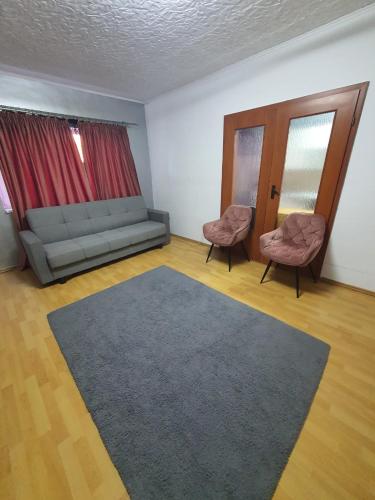 a living room with a couch and two chairs at Apartament 2 camere cazare in Zalău