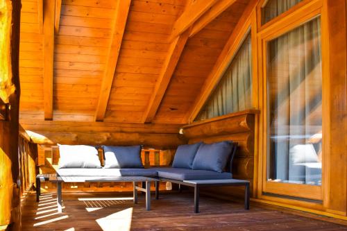 a porch with a blue couch and a window at Villa Korina in Fužine