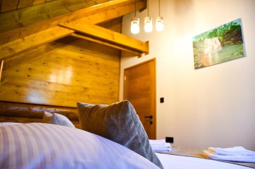 a bedroom with a bed and a wooden wall at Villa Korina in Fužine