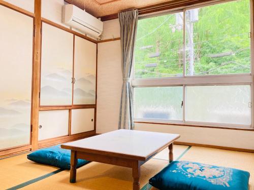 Pokój ze stołem i oknem w obiekcie Guesthouse KAZURABASHI w mieście Miyoshi