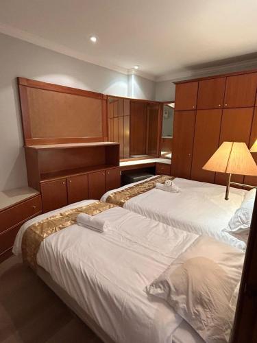 una camera d'albergo con due letti e una lampada di Riverbank suites apartment level 9 a Kuching