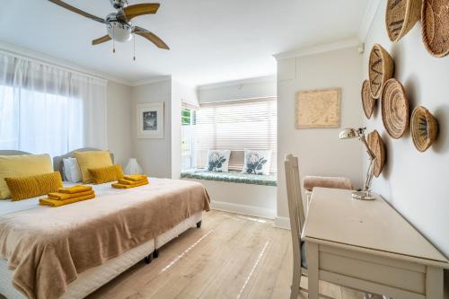 a bedroom with a bed and a desk and a window at Pezula 's Paradise in the Sun - No Loadshedding in Knysna