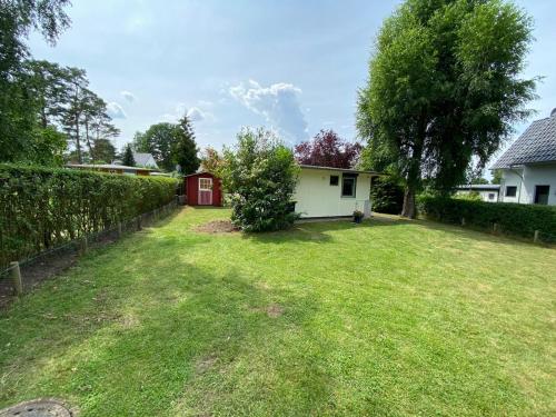 a yard with a red and white house at Bungalow Guilietta in Göhren-Lebbin