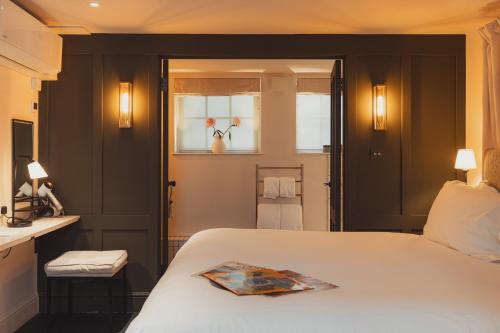 a bedroom with a bed with a magazine on it at No 15 by GuestHouse, Bath in Bath