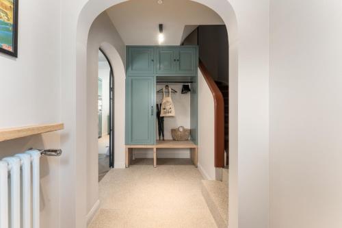 a hallway with a blue cabinet in a house at Villa Manouchka - Verblijf in alle luxe aan zee in De Haan