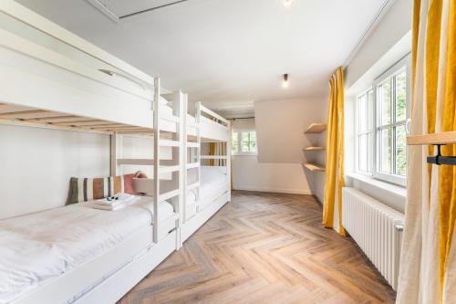 a bedroom with bunk beds in a house at Villa Manouchka - Verblijf in alle luxe aan zee in De Haan