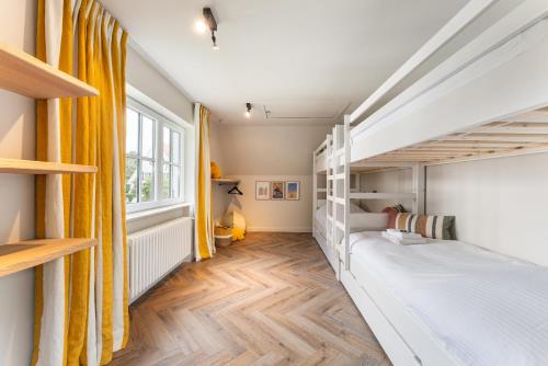 a bedroom with a bunk bed and wooden floors at Villa Manouchka - Verblijf in alle luxe aan zee in De Haan