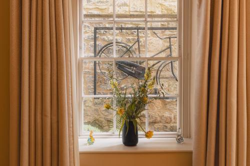a vase of flowers sitting on a window sill at No 15 by GuestHouse, Bath in Bath