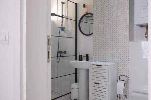 a white bathroom with a sink and a mirror at Apartmani "U gostima" Sarajevo Centar - Apartments "Be Our Guest" Sarajevo Center in Sarajevo