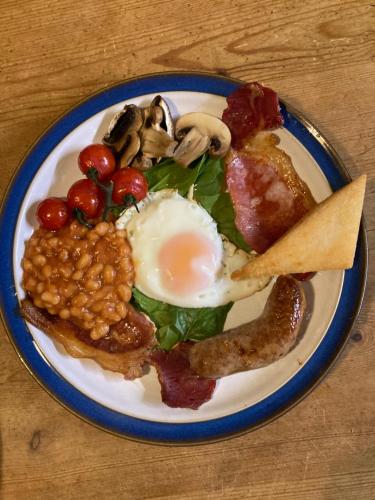 a plate of food with eggs bacon beans and mushrooms at Lisle Combe in Ventnor