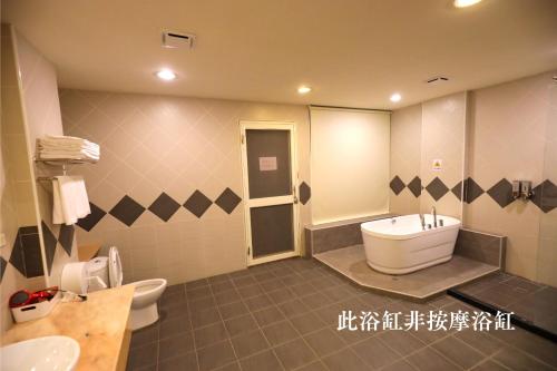 y baño con bañera, aseo y lavamanos. en TokuGawa Hotel, en Shuili