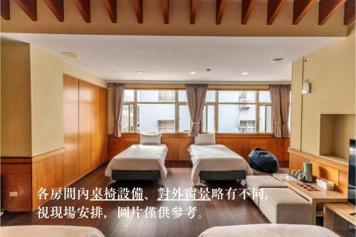 1 dormitorio con 2 camas en una habitación con ventanas en TokuGawa Hotel, en Shuili
