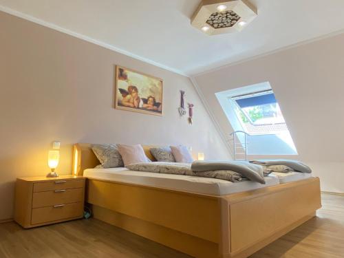 Schlafzimmer mit einem Bett und einem Fenster in der Unterkunft Ferienwohnungen Roiser in Bad Wörishofen