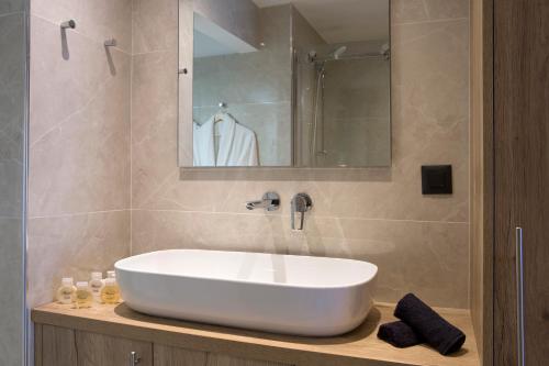 a bathroom with a white sink and a mirror at La Residence Athens in Athens