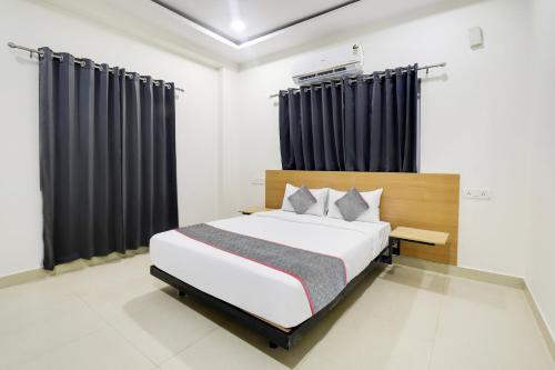 um quarto com uma cama grande e cortinas pretas em Townhouse De Alphabet Hotel Kukatpally Nexus Mall em Kukatpalli