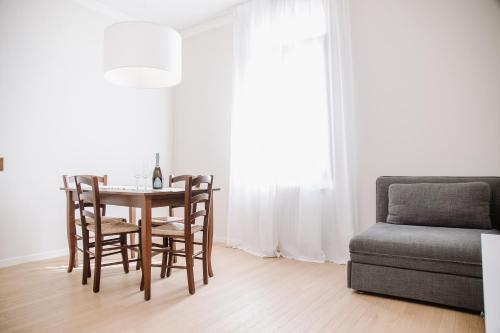 a dining room with a table and chairs and a couch at Prosecco Collalto Lodge in Susegana