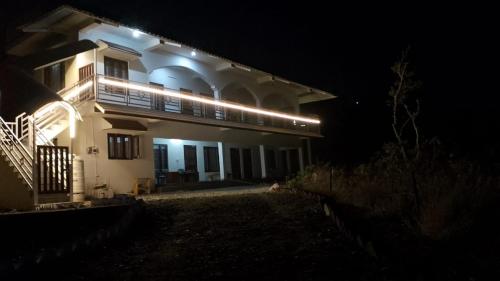 a white house with lights on it at night at Cherry Binhar, Matogi in Kāta Patthar