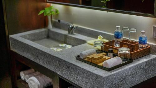 a bathroom sink with a tray of cheese and bottles of water at G Mekong Hotel Phom Penh in Phnom Penh